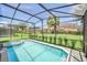 Bask in the sun by the screened pool and hot tub in a private backyard with lush landscaping at 7263 Oakmoss Loop, Davenport, FL 33837