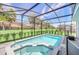 Inviting pool and spa within a screened enclosure, set against a backdrop of green lawns and trees at 7263 Oakmoss Loop, Davenport, FL 33837