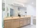 A full bathroom showcasing double sinks, a large mirror, and a soaking tub in the background at 7323 Cypress Grove Rd # 87, Orlando, FL 32819