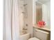 Clean, white bathroom featuring a bathtub-shower with white tiling and sleek fixtures at 7323 Cypress Grove Rd # 87, Orlando, FL 32819