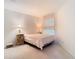 Cozy bedroom with carpet, a large bed, side table and lamp. A window lets in natural light at 7323 Cypress Grove Rd # 87, Orlando, FL 32819
