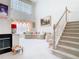 Elegant living room with a high ceiling, fireplace, staircase, and plush furnishings at 7323 Cypress Grove Rd # 87, Orlando, FL 32819