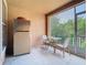 Enclosed patio featuring tile flooring, seating, and a refrigerator at 7323 Cypress Grove Rd # 87, Orlando, FL 32819