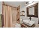 Stylish bathroom featuring stone tiled shower, vessel sink, and rustic wood mirror at 8248 Limetree Ct, Orlando, FL 32836