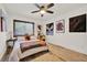 Bedroom with ceiling fan, wood-look floors, and whimsical artwork at 8248 Limetree Ct, Orlando, FL 32836