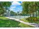 Community tennis court surrounded by mature trees and lush landscaping at 8248 Limetree Ct, Orlando, FL 32836