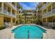Inviting pool with building views, palm trees, lounge chairs, and clear blue water at 860 N Orange Ave # 448, Orlando, FL 32801