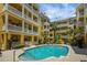 Inviting pool with building views, palm trees, lounge chairs, and clear blue water at 860 N Orange Ave # 448, Orlando, FL 32801
