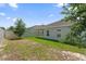 Spacious backyard featuring green grass, fencing, and a covered patio at 9356 St Therese St, Groveland, FL 34736