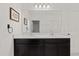 Bright bathroom with a double sink vanity, large mirror, and a white color palette at 9356 St Therese St, Groveland, FL 34736