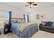 Comfortable bedroom featuring a ceiling fan, a cozy sitting area and natural light from the window at 9356 St Therese St, Groveland, FL 34736
