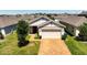 Well-maintained home features a brick driveway, lush lawn, and a two-car garage at 9356 St Therese St, Groveland, FL 34736