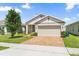 Charming single-Gathering home features a brick driveway, two-car garage, and manicured landscaping at 9356 St Therese St, Groveland, FL 34736