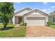Charming single-story home featuring a brick driveway, a two-car garage, and a neatly maintained lawn at 9356 St Therese St, Groveland, FL 34736