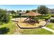 Community playground with a covered play structure and swings at 9356 St Therese St, Groveland, FL 34736