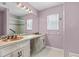Bathroom with double sinks, decorative mirror, tiled backsplash and lighting at 9447 Brackin St, Orlando, FL 32825