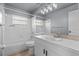 Clean bathroom featuring a white vanity, tiled shower, and mirrored wall at 9447 Brackin St, Orlando, FL 32825