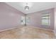 Serene bedroom with three windows, tile flooring, and neutral colored walls at 9447 Brackin St, Orlando, FL 32825