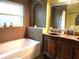 Elegant bathroom features a bathtub, vanity with sink, and a built-in shower niche at 983 Bucksaw Pl, Longwood, FL 32750