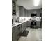 Modern kitchen with gray cabinets, stainless steel appliances, sleek countertops, and stylish backsplash, ready for culinary adventures at 983 Bucksaw Pl, Longwood, FL 32750