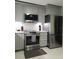 Modern kitchen with stainless steel appliances, gray cabinets, and stylish backsplash at 983 Bucksaw Pl, Longwood, FL 32750