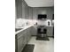 Modern kitchen with gray cabinets, stainless steel appliances, sleek countertops, and stylish backsplash, ready for culinary adventures at 983 Bucksaw Pl, Longwood, FL 32750