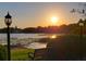 Serene lake view featuring a tranquil bench and stunning sunset at 983 Bucksaw Pl, Longwood, FL 32750