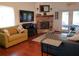 Inviting living room with a brick fireplace, comfortable seating, and wood flooring at 983 Bucksaw Pl, Longwood, FL 32750