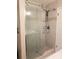 Modern bathroom shower with a glass door, white tiles, and contemporary fixtures at 983 Bucksaw Pl, Longwood, FL 32750