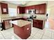 Well-lit kitchen with dark cabinets, granite countertops, stainless steel appliances, and center island at 12756 Maribou Cir, Orlando, FL 32828