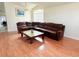 Elegant living room with vaulted ceilings, wood floors, a large sectional sofa, and a glass coffee table at 12756 Maribou Cir, Orlando, FL 32828
