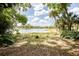 Backyard featuring a scenic lake view with mature trees, beautiful landscaping, and a black fence at 1502 E Gore St, Orlando, FL 32806
