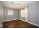 Neutral bedroom featuring hardwood floors, two windows, and minimal decor at 1502 E Gore St, Orlando, FL 32806