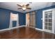 Bedroom featuring blue walls, wood flooring, and bathroom access via rustic sliding barn door at 1502 E Gore St, Orlando, FL 32806