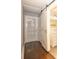 Hallway featuring wood flooring, a closet, and a bathroom with a white sliding barn door at 1502 E Gore St, Orlando, FL 32806