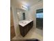 Modern bathroom showcasing double sinks, dark cabinets, and a large mirror at 1575 Aspen Ave, Davenport, FL 33837