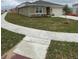 Side view of a charming single-story home with well-maintained lawn and a two car garage at 1575 Aspen Ave, Davenport, FL 33837