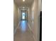 Long hallway with tiled floors leading to the front door at 1575 Aspen Ave, Davenport, FL 33837