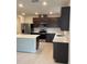Modern kitchen featuring stainless steel appliances, dark cabinetry, and a bright countertop island at 1575 Aspen Ave, Davenport, FL 33837