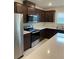 Well-equipped kitchen featuring stainless steel appliances and dark wooden cabinetry, plus bright countertops at 1575 Aspen Ave, Davenport, FL 33837