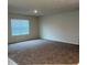 Open-plan living room featuring carpet flooring and a large window, offering ample natural light at 1575 Aspen Ave, Davenport, FL 33837
