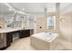 Elegant bathroom featuring a deep soaking tub, dual vanities, decorative mirrors and walk in shower at 1601 Stargazer Ter, Sanford, FL 32771