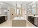 A luxurious bathroom with dual sinks, a soaking tub, walk in shower, and warm-toned tile at 1601 Stargazer Ter, Sanford, FL 32771