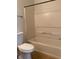 An interior bathroom view with a toilet, tub with shower, and towel bar at 2007 Dixie Belle Dr # 2007 M, Orlando, FL 32812