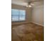 The spacious bedroom features neutral paint, a ceiling fan and a large window at 2007 Dixie Belle Dr # 2007 M, Orlando, FL 32812