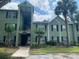 Condo building with green exterior, black shutters, and tropical landscaping at 2007 Dixie Belle Dr # 2007 M, Orlando, FL 32812