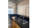 Kitchen with stainless steel sink and black granite countertops with pass through to living area at 2007 Dixie Belle Dr # 2007 M, Orlando, FL 32812