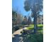 Beautifully landscaped walkway with mature trees, lush lawn, and decorative rock accents at 2007 Dixie Belle Dr # 2007 M, Orlando, FL 32812