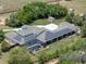 Birds-eye view of the home with solar panels, a screened-in pool, and sprawling acreage at 20199 Sweetwood Ln, Clermont, FL 34715