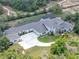 Aerial view of estate featuring manicured lawns, ample parking, and screened pool at 20199 Sweetwood Ln, Clermont, FL 34715